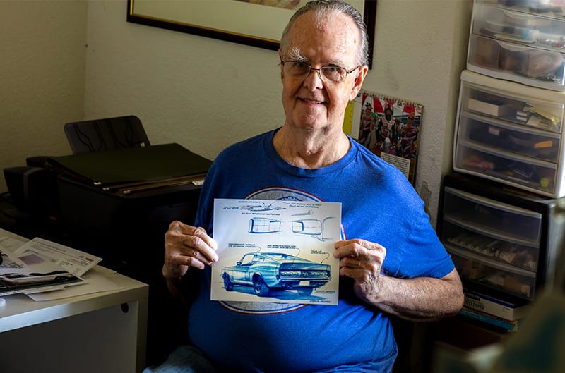 Charlie McHose holding up the blue sketch of the Shelby Mustang GT500