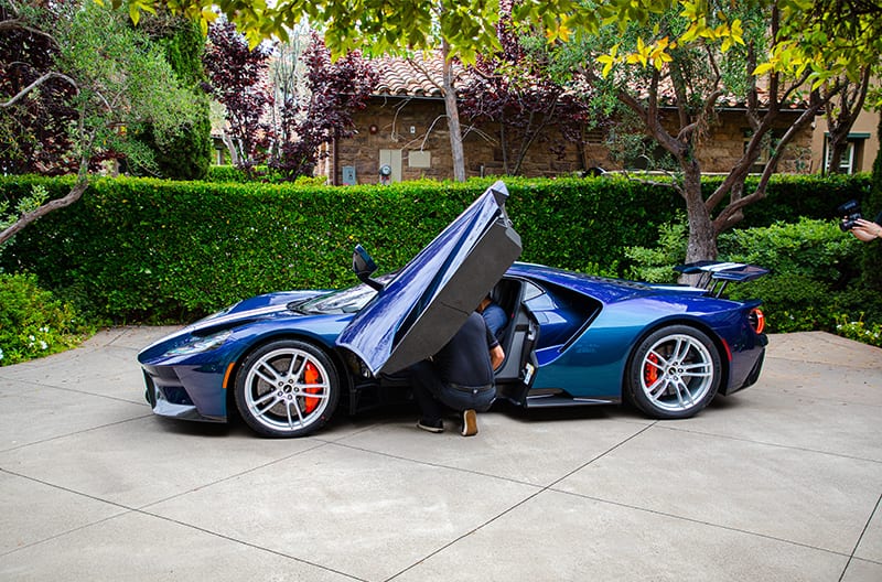 Profile of Mystichrome GT with driver door open and man looking in front seat parked on driveway