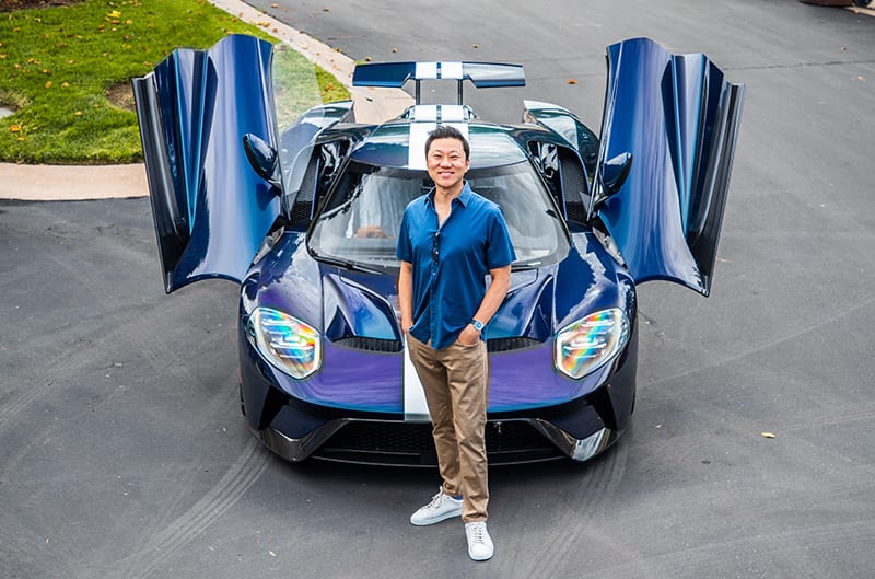 Justin Choi standing in front of his Mystichrome GT with the doors up in the street