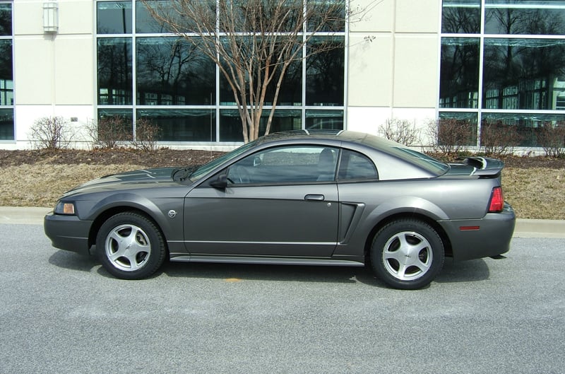Profile of dark gray Mustang in front of dealership