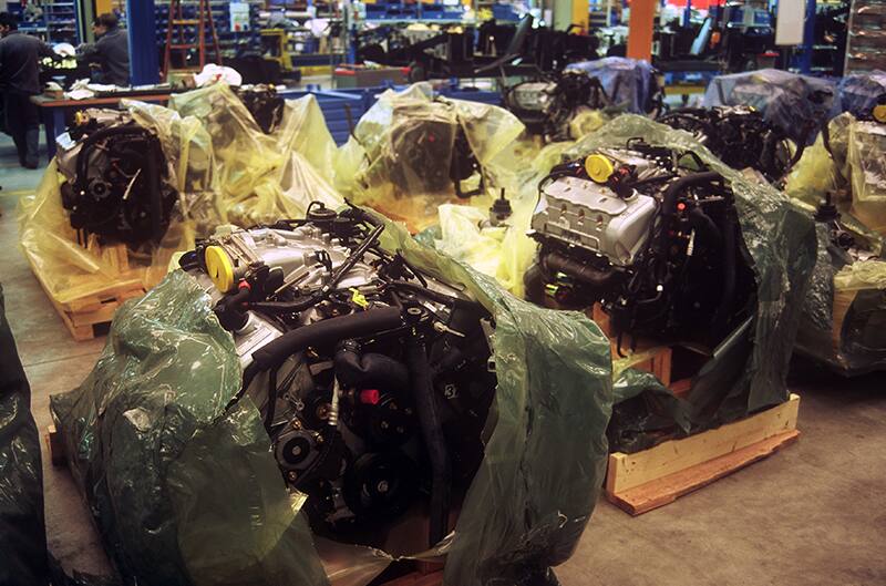 Various engines covered in plastic in a garage