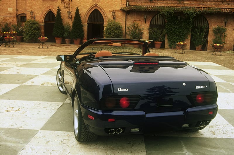 Rear of black Qvale Mangusta in courtyard