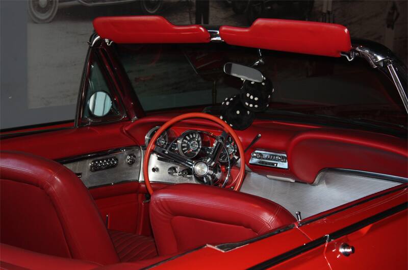 Interior close up from behind passenger side of front seat of red Thunderbird droptop