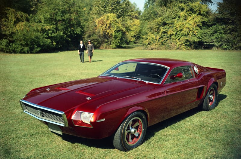 Front profile of a red Mustang Mach 1 in the grass