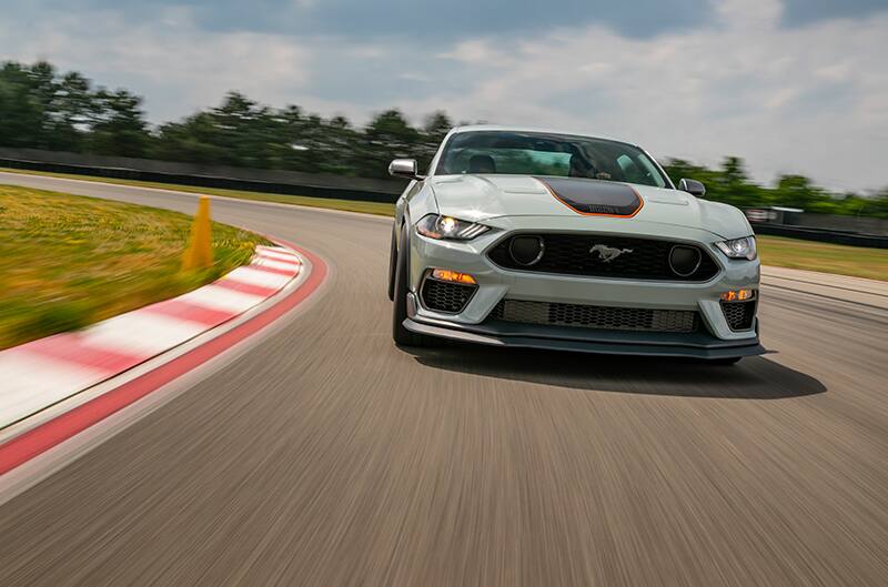 Front of a white Mustang Mach 1 driving on the track