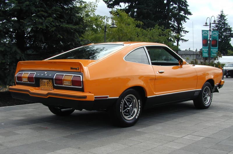 Rear profile of orange Mustang Mach 1 on pavement