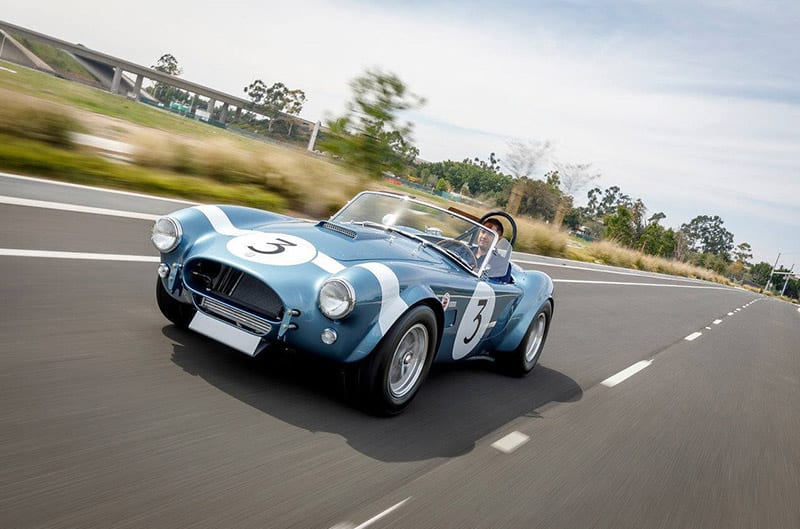 Blue and white Shelby Cobra driving photo