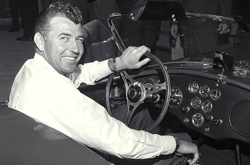 Carroll Shelby looking back from the drivers seat of Cobra black and white photo