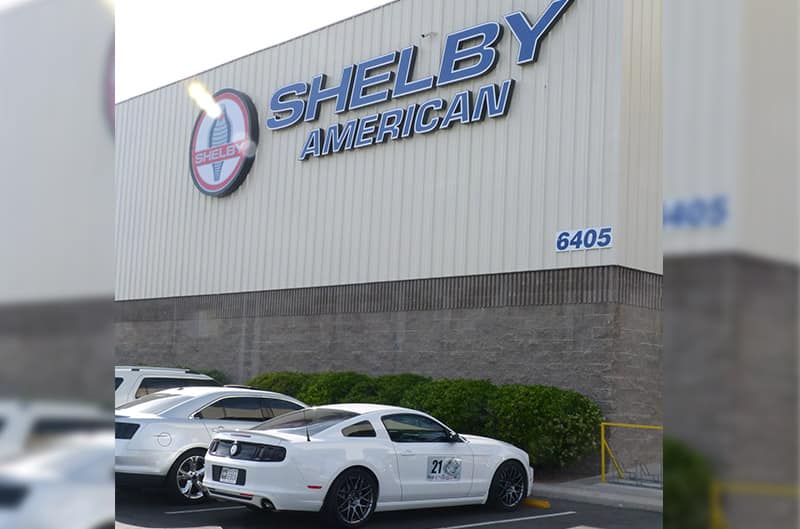 Shelby American building exterior with mustang parked in front