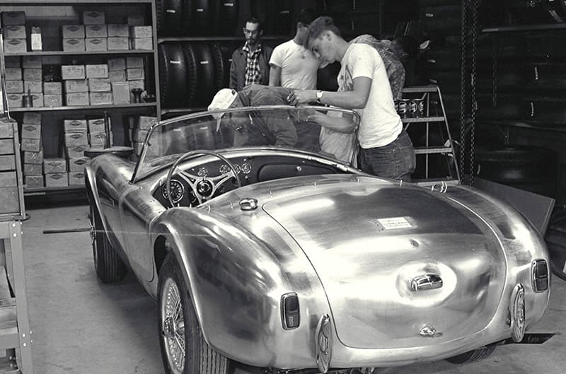 Cobra being worked on by Moon employee inside shop black and white photo