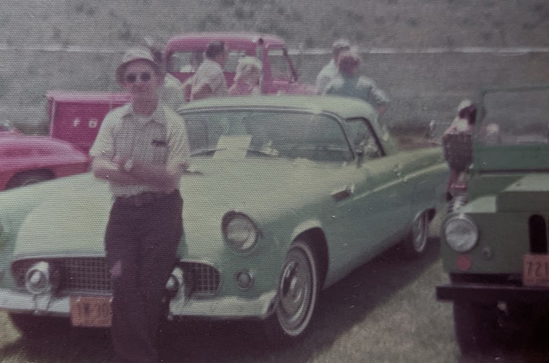 man standind in front of vehicle at car show