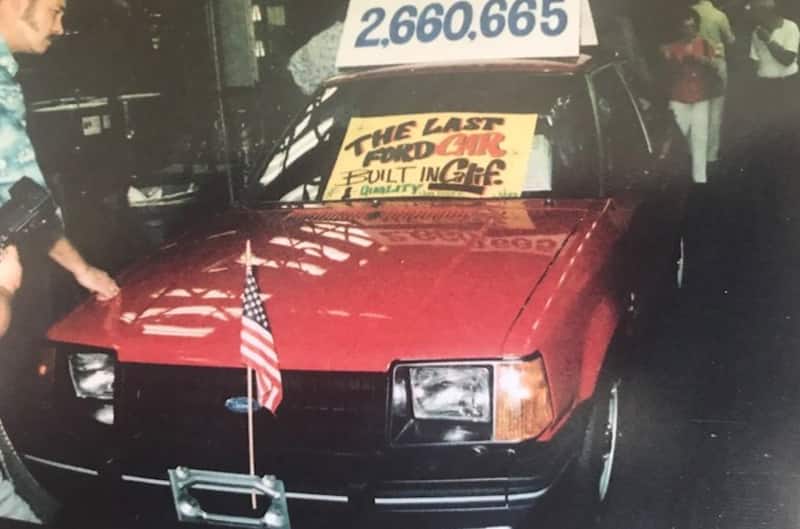 vehicle rolling off the assembly line with poster on front windshield