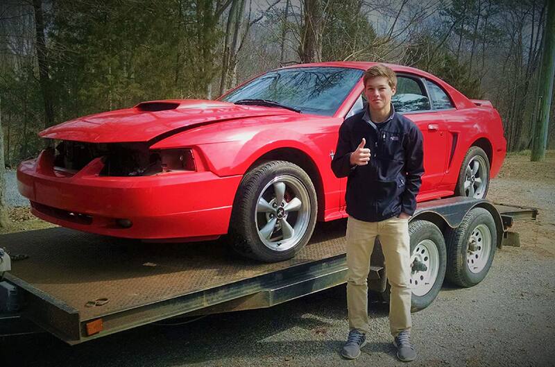 Brandon standing in front of Newedge mustang on trailer