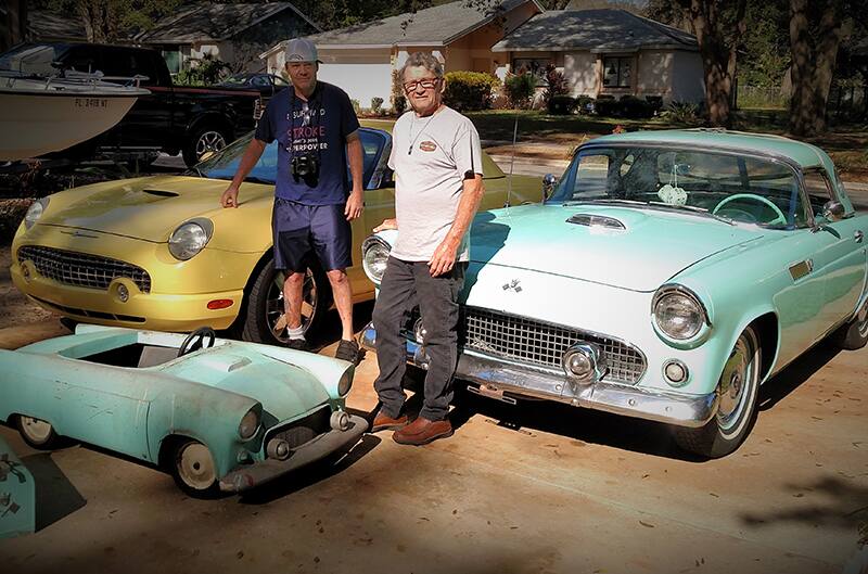 Al and Doug standing with old and new thunderbirds and thunderbird pedal car