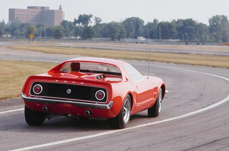 This is the Mach 2 on Ford’s Dearborn Proving Grounds. The red car handled well, but still experienced some body roll, as seen here. Due to lower speeds, this roll is not as severe as that experienced during high-speed testing of the white race car.