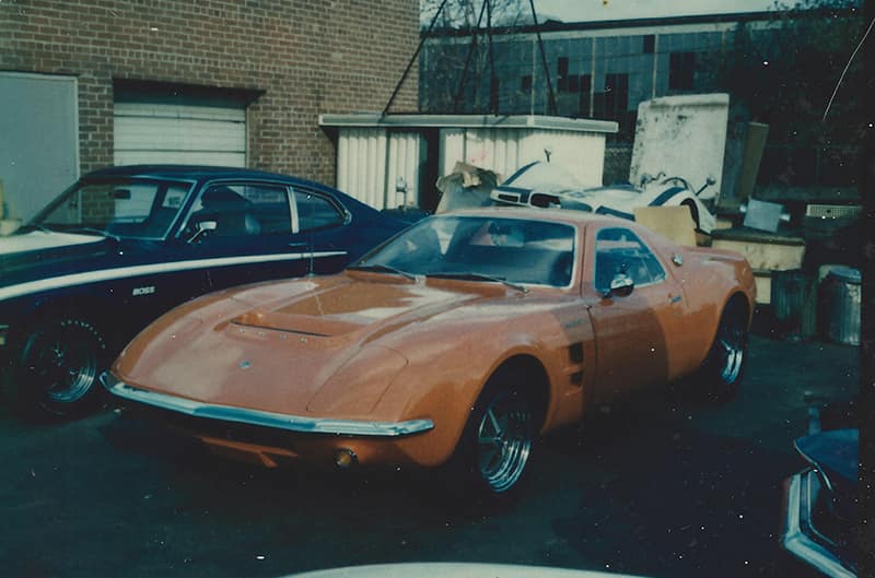 The red Mach 2 Concept car (the color in this aged photo is distorted) is seen callously parked behind the Kar-Kraft shop with other cast aside projects – a Boss 302 Maverick prototype and a front clip from the G7-A Can Am car. The Maverick’s presence indicates the picture may have been taken some time in 1970, well past the Mach 2’s corporate usefulness. The car may have been waiting for its final disposition at this time.