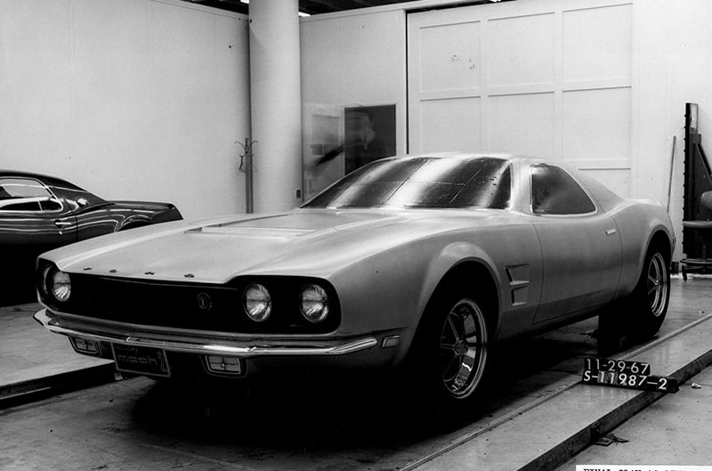 This is what the Mach 2 would have looked like, had it gone into production. The car’s front end was intended to ‘predict’ the 1971 Mustang’s appearance. Note the asymmetrical front grille treatment, often done to provide two perspectives of a design. In this case, one side represented the car with single headlights, the other side with dual lights. The license plate clearly reads ‘Mustang Mach 2.’ The dark car beside the clay is the original red prototype Mach 2A.