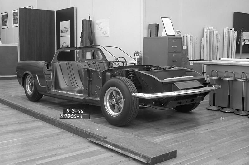 The date of this photo, May 2, 1966, corresponds with the management reveal of the mock-up. It shows how quickly the studio and Kar-Kraft responded to the March 22 request. The 1966 Mustang is recognizable by the front suspension, lower frame rails, front crossmember, rocker panel and rear fender. The bumpers are stock and in their stock Mustang locations. The cut-down, sloping profile of the aprons, from the spring to the radiator support, is obvious. Sheet-metal duct work reinforces the aprons and directs air to the repositioned radiator.