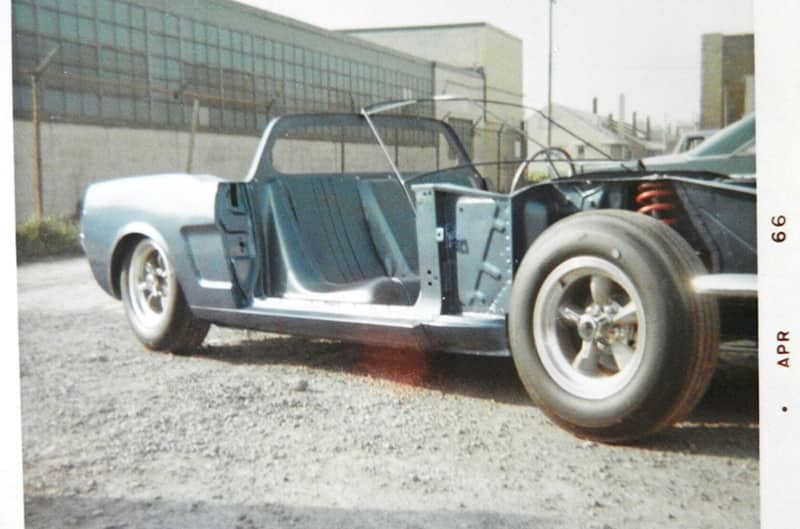 Here’s the light-blue 1966 feasibility chassis parked beside the Kar-Kraft shop. The stock appearance and the height of the apron at the spring tower can be seen. The Mustang windshield frame has been removed. A windshield frame was fabricated out of small-diameter tubing to represent the Design Center’s laid-back design.