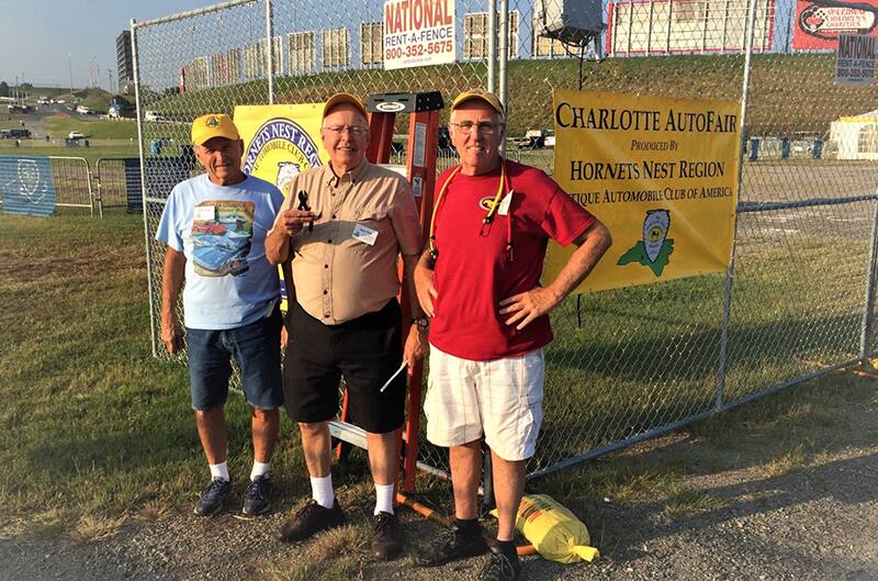 Group of men standing by Charlotte autofair sign