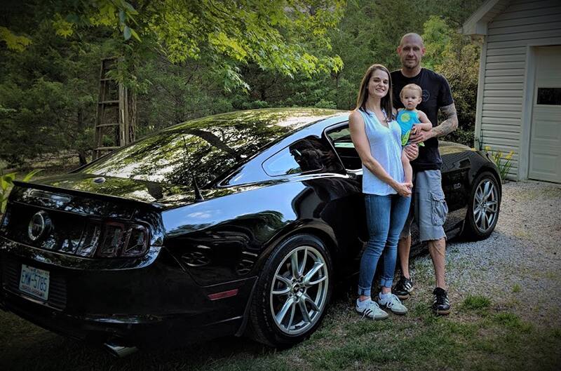 Chip and Devon and Laken standing with their Mustang