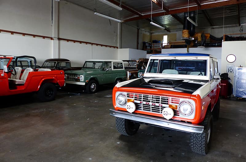 Overview of small shop with several different colored early model broncos
