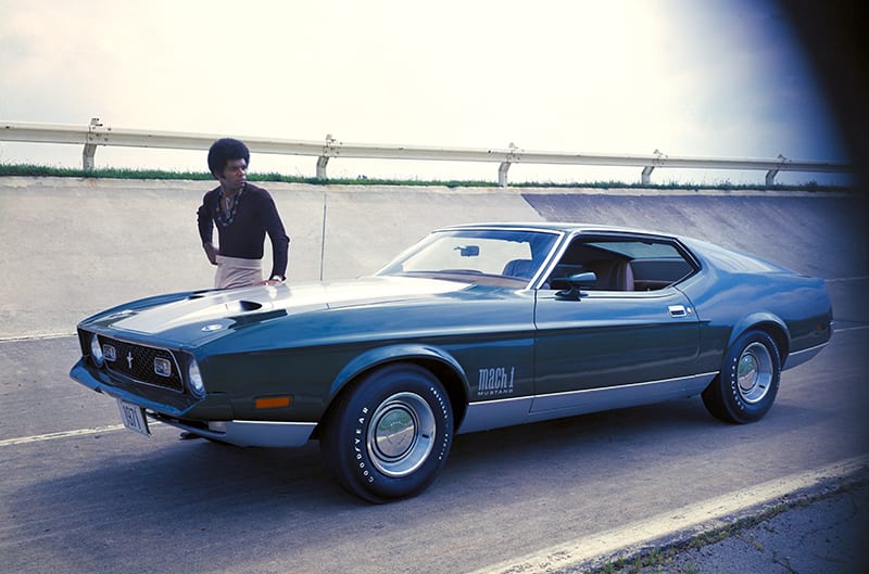 1971 Mach 1 Fastback mustang with man standing on opposite side of car