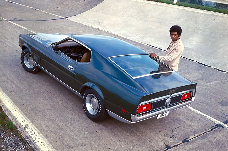 1971 Ford Mustang high angle photo from rear with man standing opposite side of car