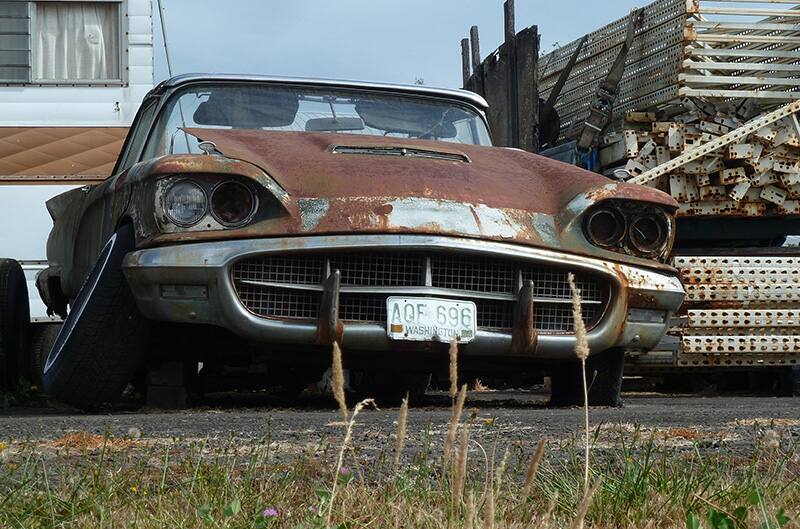 Rusty ford with tire falling off