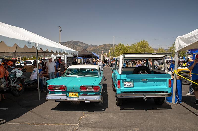 Light blue Bronco and edsel parked parallel