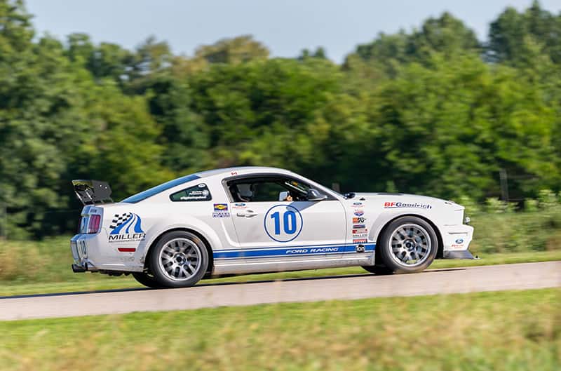 White and blue S197 Mustang on track