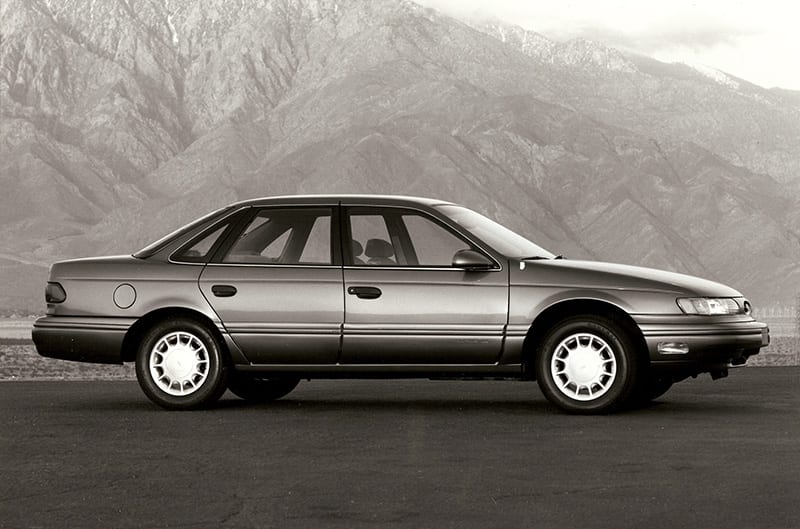 Black and white photo of ford taurus in mountains