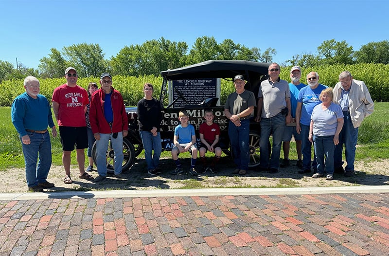 group of people standing by model t