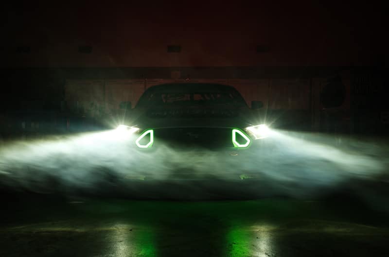 A Mustang RTR shines light with a slight green hue into the dark