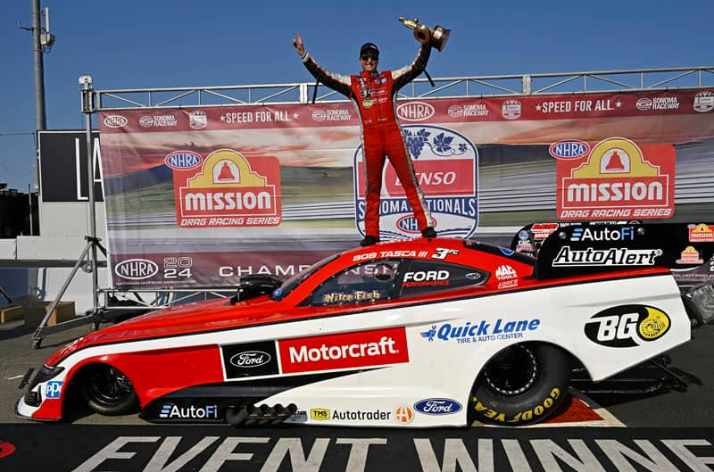 Tasca celebrating on top of Mustang