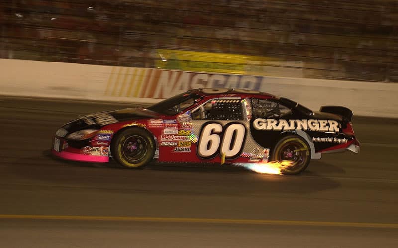 Biffle's black and red Number 60 Grainger Ford Taurus is pictured speeding through a track