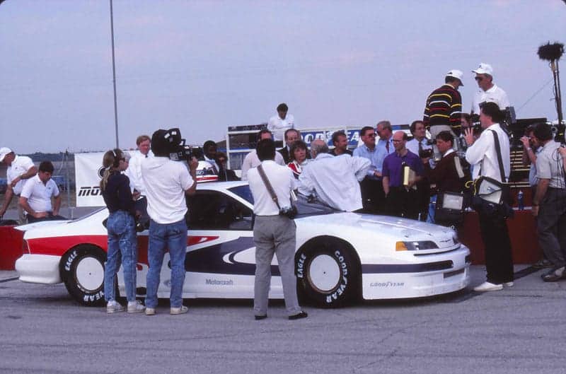 With the 1989 Thunderbird next to her, St James is pictured getting interviewed by the media at a track