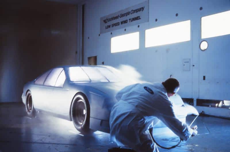 The 1989 Ford Thunderbird getting spray painted in white inside a low speed wind tunnel
