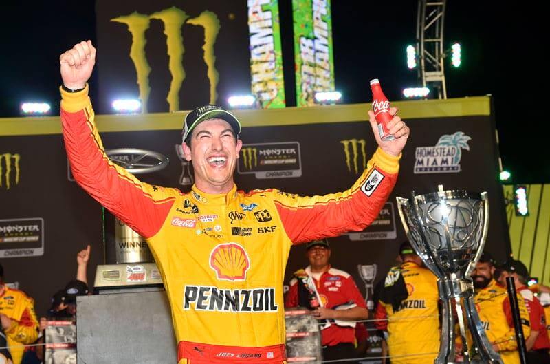 Logano celebrates win with a Coca-Cola drink in his hand at Victory Lane