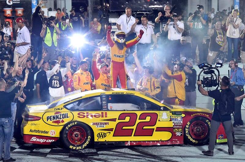 Team Penske and fans cheer on with Logano, who is standing on top of his Number 22 Fusion, to celebrate NASCAR Cup Championship victory