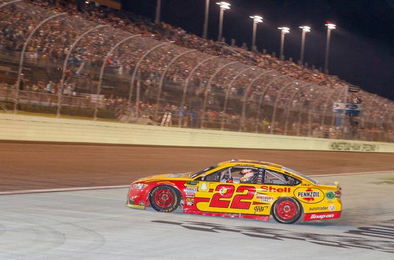 Logano is pictured inside his Number 22 Shell Pennzoil Ford Fusion with a full crowd watching from the stands at the Homestead-Miami track