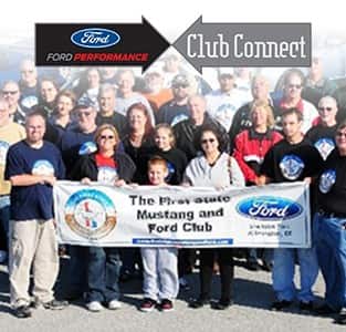 Ford Enthusiasts standing in front of a Ford Banner
