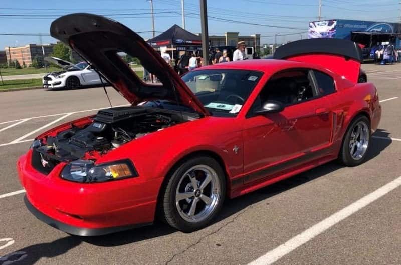 Red 2003 Mustang Mach 1 in parking lot with hood and trunk open