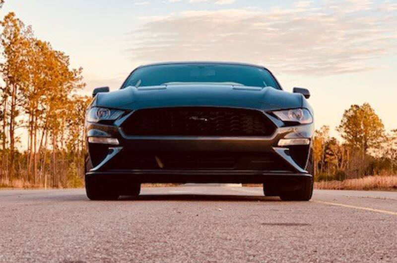 Close up front of a black Mustang on the road 