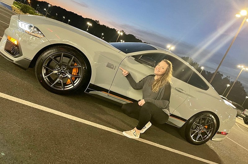 Woman posing with 2021 Mach 1 Mustang
