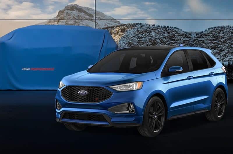 Front profile of blue Edge in front of a covered Ford Performance vehicle with a mountain scene backdrop behind it