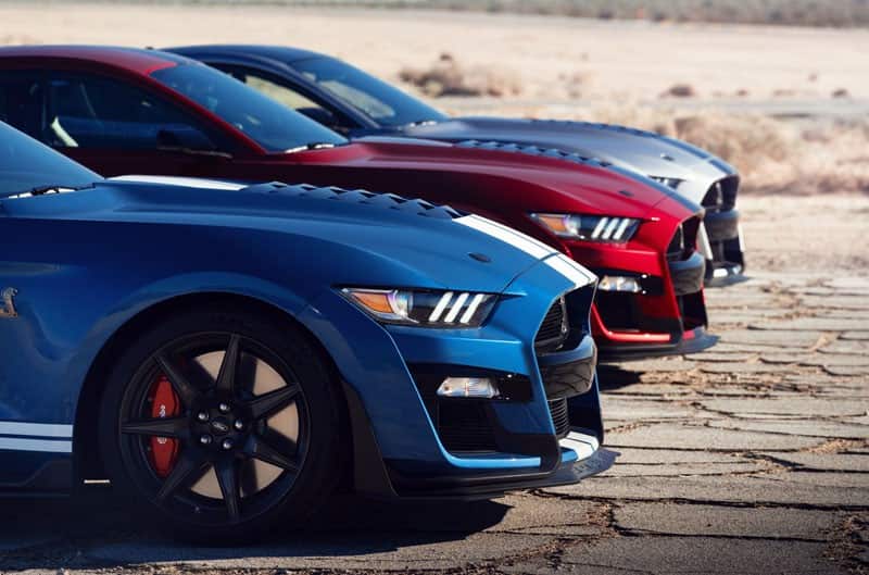 The front side of a blue, a grey and a red Mustang 