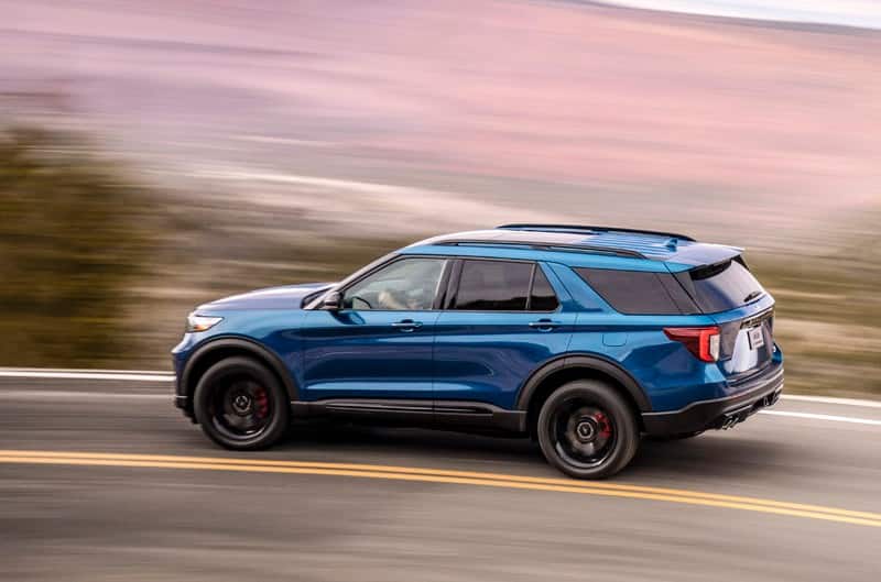 A blue Ford Explorer driving down the road 