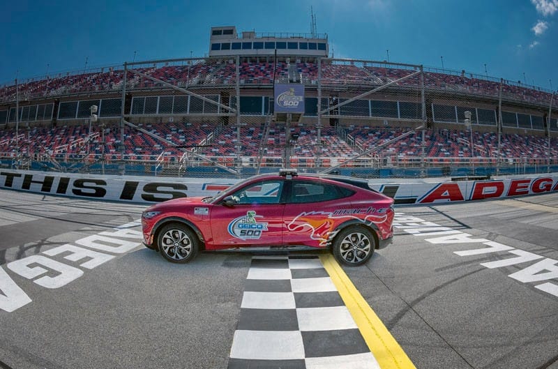 Profile of red Mustang Mach-E on the track at Talladega