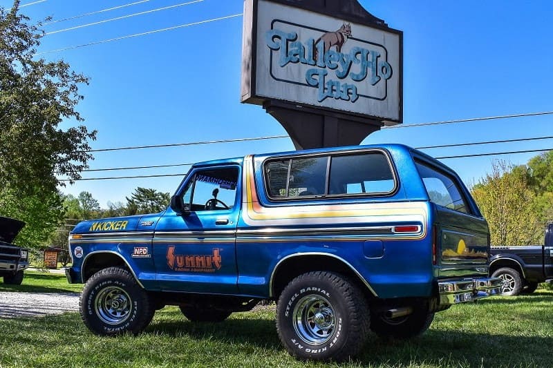 Blue Bronco in front of Tally Ho Inn sign 